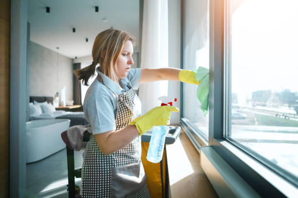 Young woman washing window